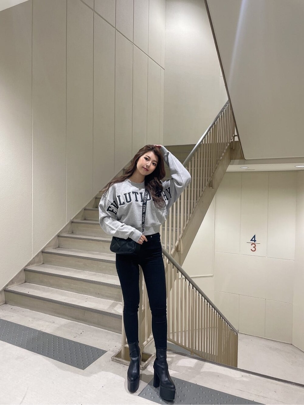 その他のデニムパンツ、ブラック系のブーツ、グレー系のスウェットを着用したレディースの秋コーディネートの2枚目の写真