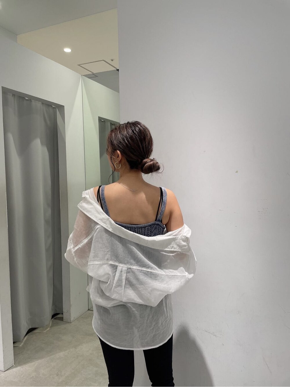 ブラック系のキャミソール、ブラック系のデニムパンツ、ホワイト系のシャツ/ブラウスを着用したレディースの春コーディネートの6枚目の写真