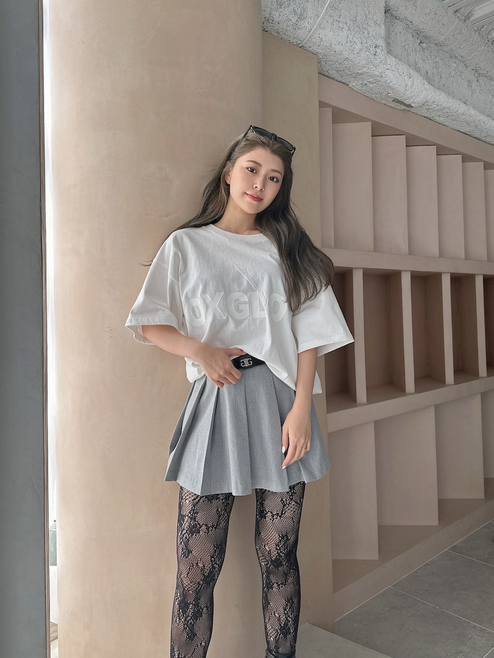 ホワイト系のTシャツ/カットソー、グレー系のスカート、ブラック系のブーツを着用したレディースの夏コーディネートの3枚目の写真