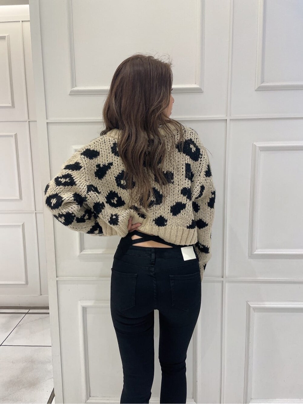 ブラック系のブーツ、ホワイト系のキャミソール、ベージュ系のカーディガン/ボレロを着用したレディースの秋コーディネートの6枚目の写真