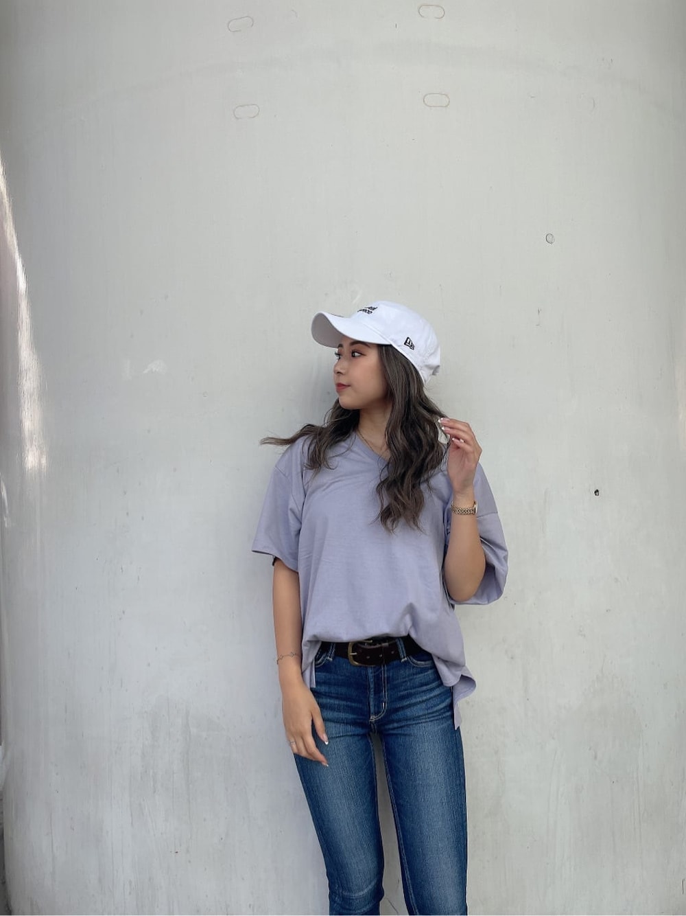 ブルー系のデニムパンツ、ホワイト系のサンダル、パープル系のTシャツ/カットソーを着用したレディースの夏コーディネートの4枚目の写真