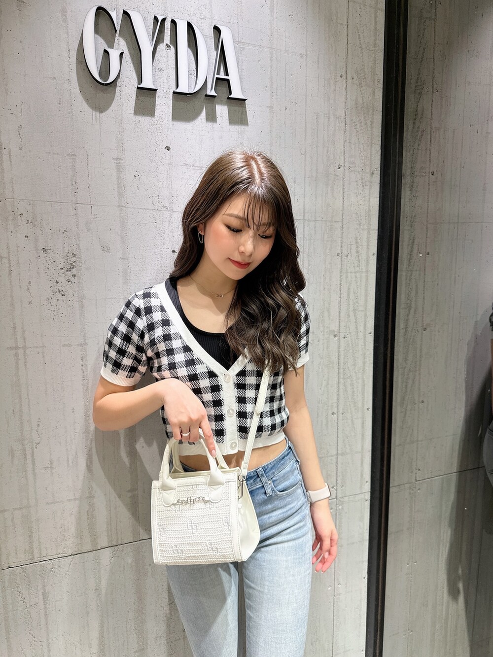 ブラック系のTシャツ/カットソー、ブラック系のカーディガン/ボレロ、ブルー系のデニムパンツを着用したレディースの春コーディネートの6枚目の写真