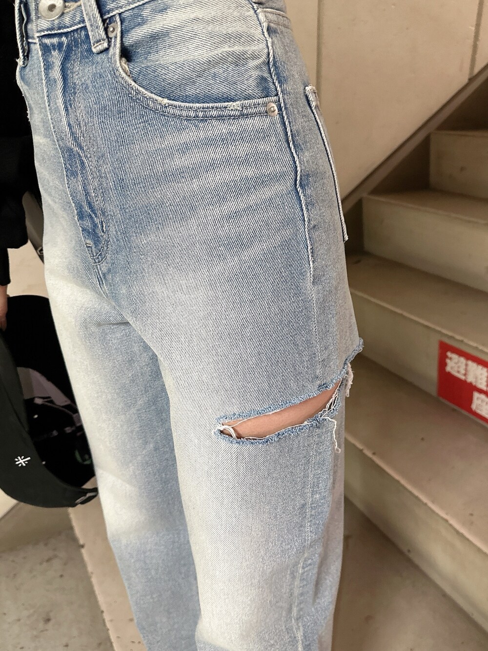 ブラック系のスウェット、ブルー系のデニムパンツ、ブラック系のバックパック/リュックを着用したレディースの冬コーディネートの9枚目の写真