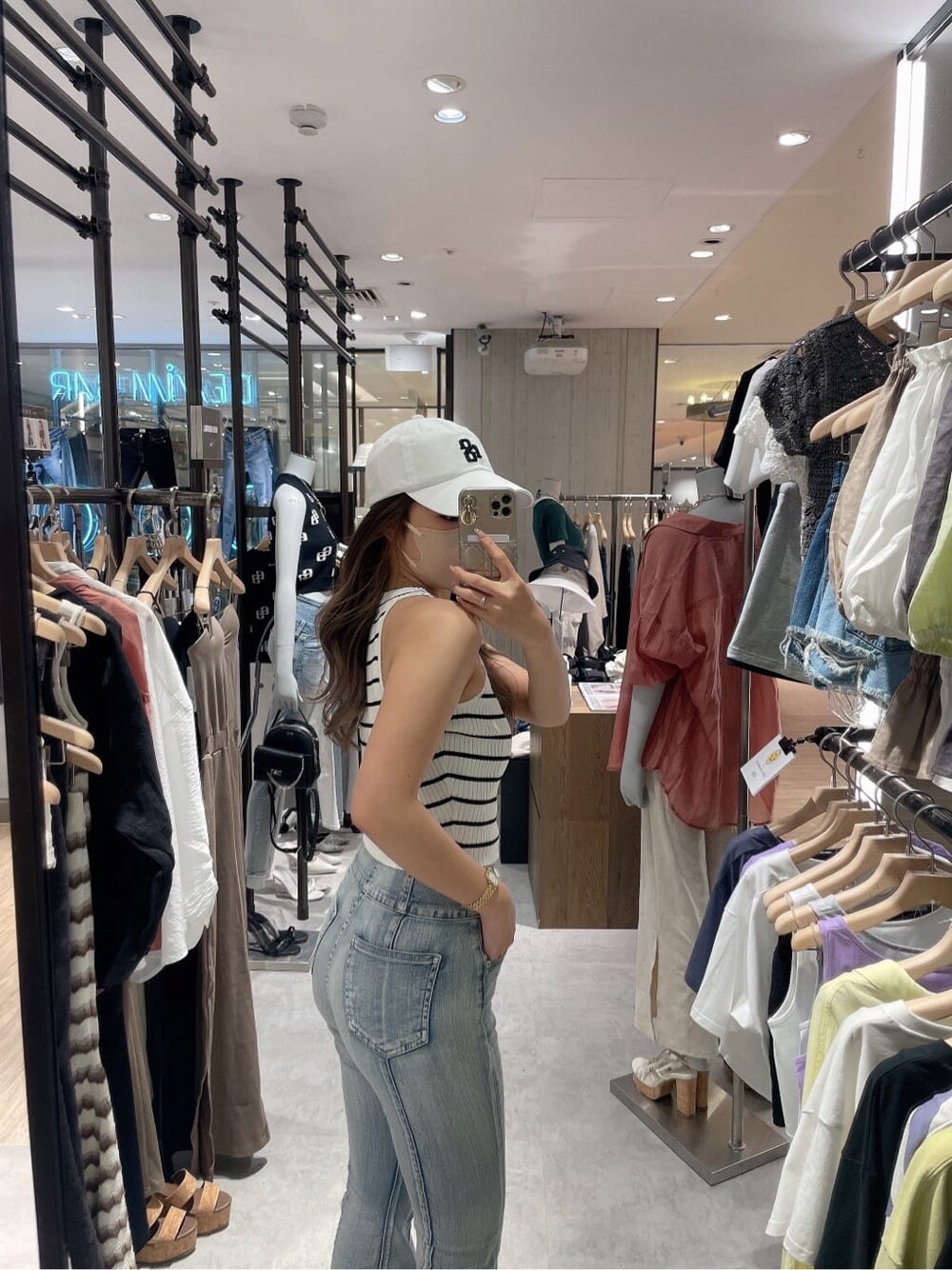 ホワイト系のサンダル、ホワイト系のタンクトップ、ブルー系のデニムパンツを着用したレディースの夏コーディネートの4枚目の写真