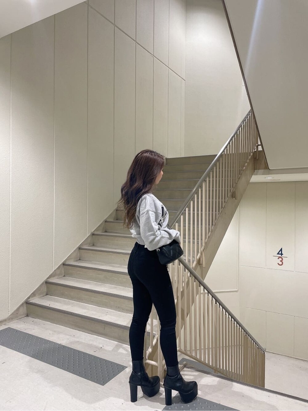 その他のデニムパンツ、ブラック系のブーツ、グレー系のスウェットを着用したレディースの秋コーディネートの3枚目の写真