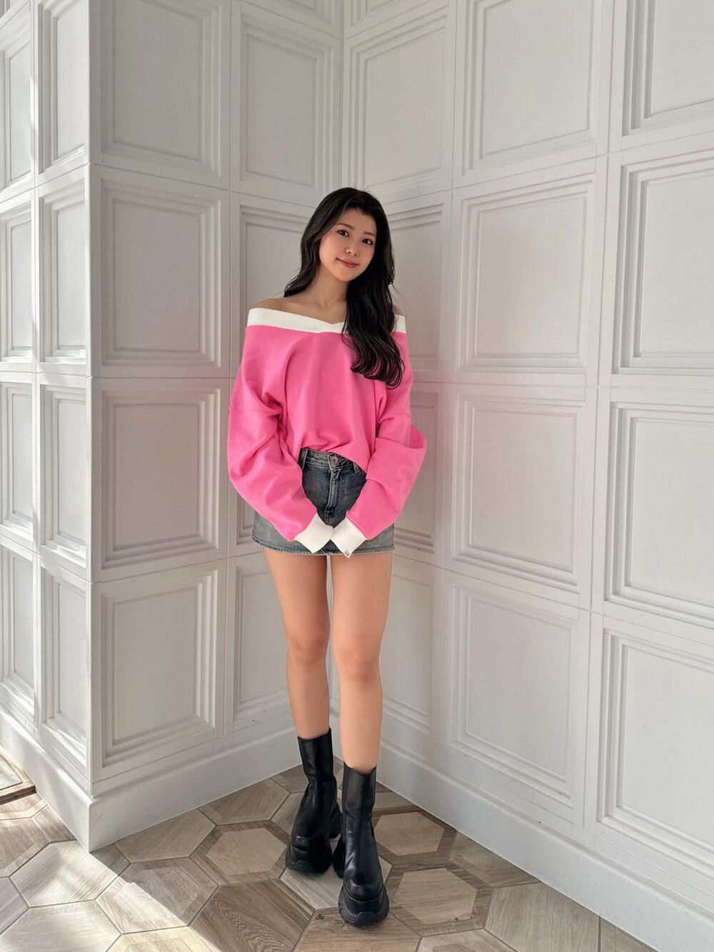 ブラック系のブーツ、ブルー系のデニムスカート、ピンク系のスウェットを着用したレディースの冬コーディネートの2枚目の写真