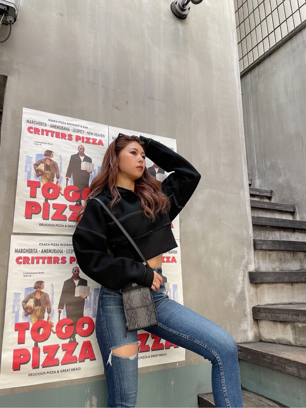 ブラック系のパンプス、ブルー系のデニムパンツ、ブラック系のパーカーを着用したレディースの秋コーディネートの5枚目の写真