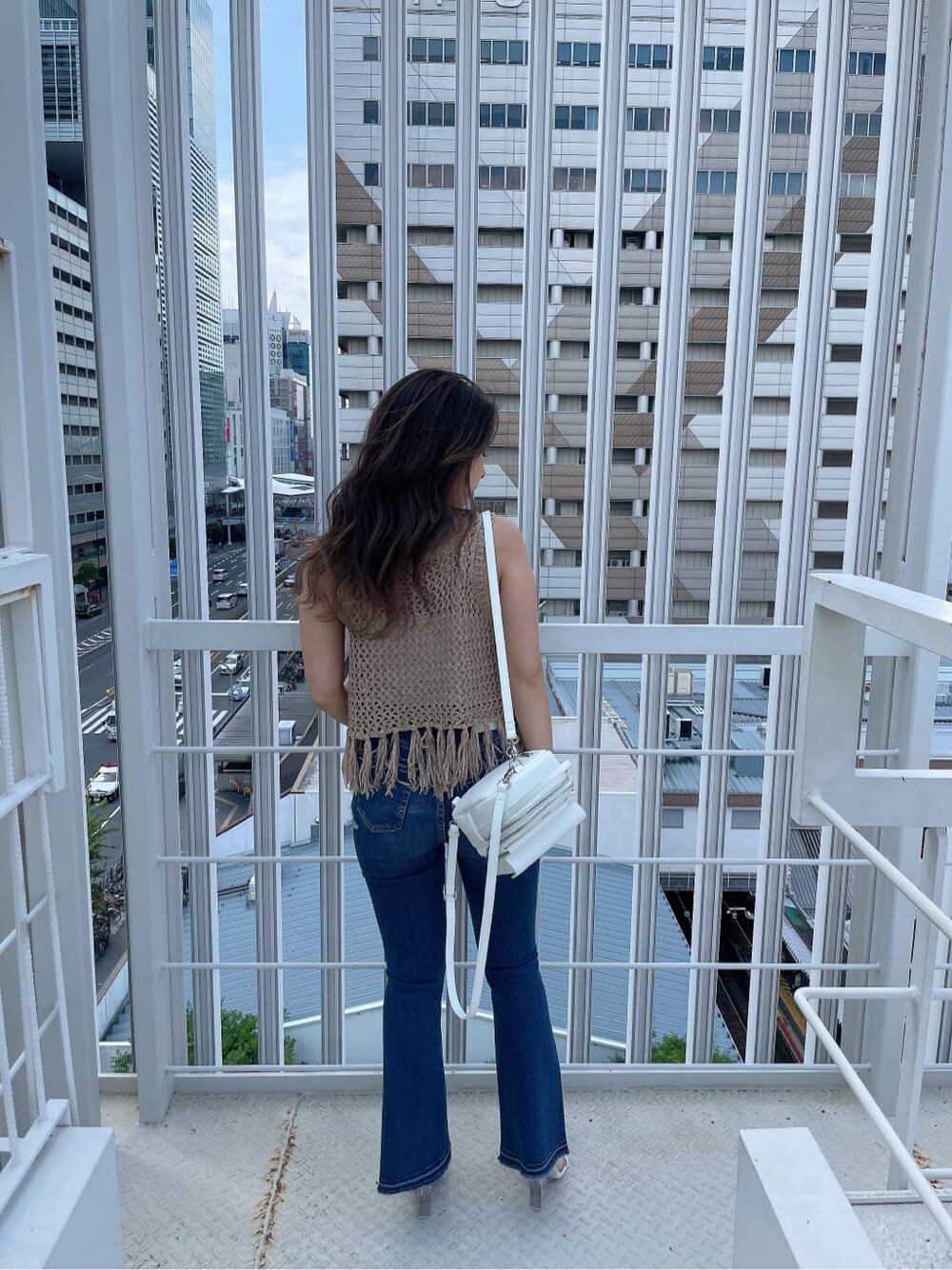 ホワイト系のサンダル、ブルー系のデニムパンツ、ホワイト系のハンドバッグを着用したレディースの夏コーディネートの4枚目の写真