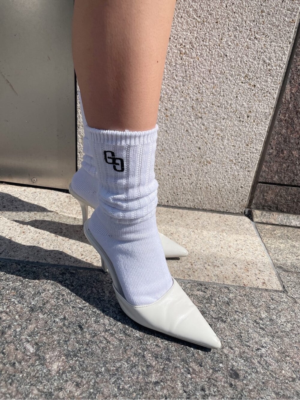 ホワイト系のパンプス、オレンジ系のシャツ/ブラウス、ブルー系のデニムパンツを着用したレディースの春コーディネートの7枚目の写真