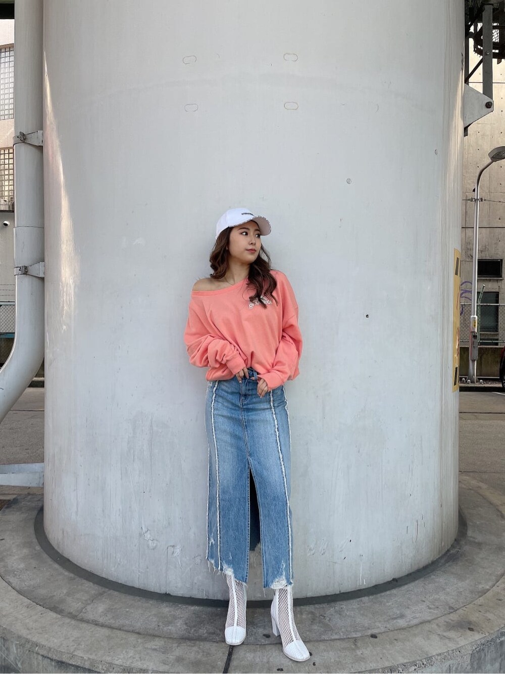 ホワイト系のブーツ、オレンジ系のスウェット、ブルー系のデニムスカートを着用したレディースの冬コーディネートの2枚目の写真