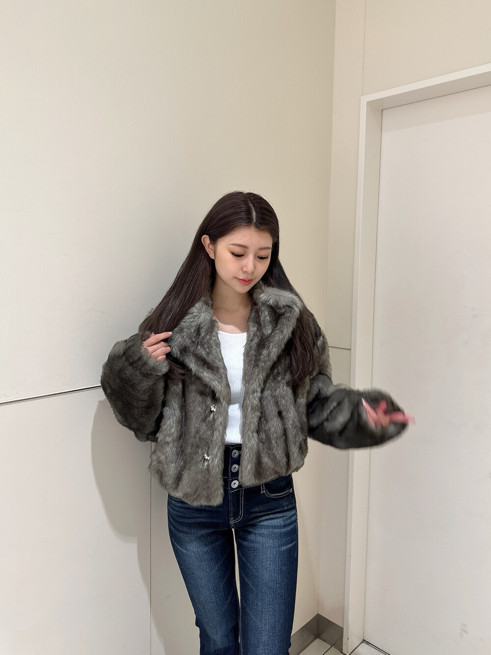 ブルー系のデニムパンツ、ホワイト系のニット/セーター、ブラック系のブーツを着用したレディースの秋コーディネートの3枚目の写真