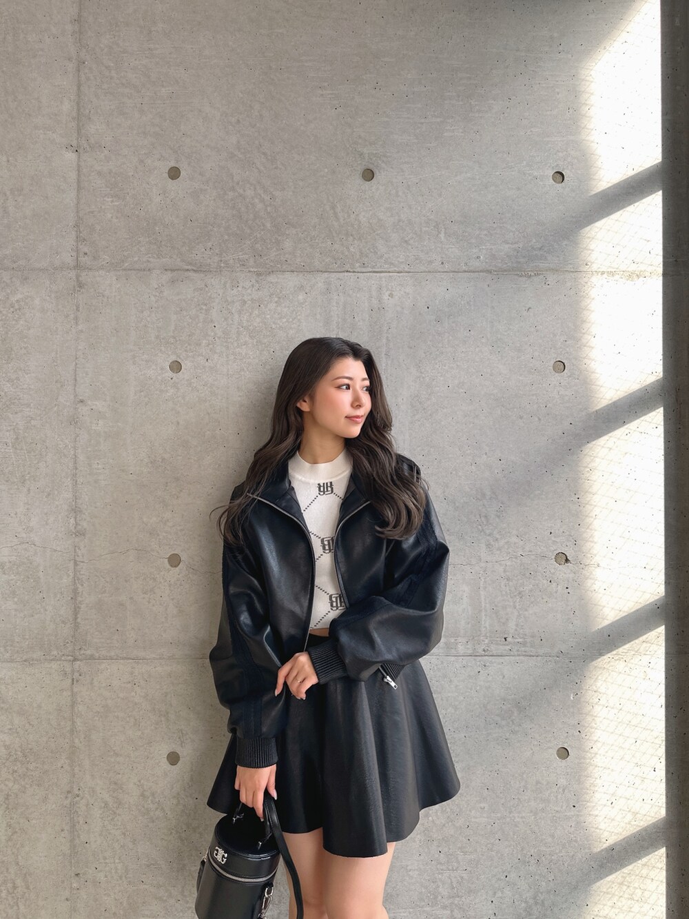 ブラック系のブーツ、ブラック系のスカート、ブラック系のブルゾンを着用したレディースの冬コーディネートの5枚目の写真