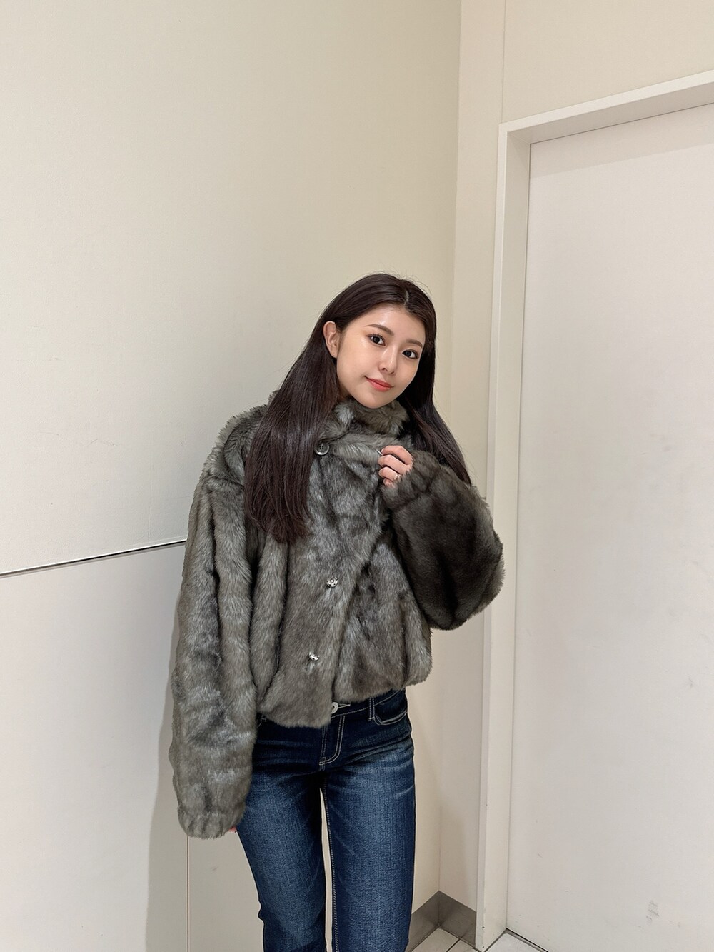 ブルー系のデニムパンツ、ホワイト系のニット/セーター、ブラック系のブーツを着用したレディースの秋コーディネートの4枚目の写真