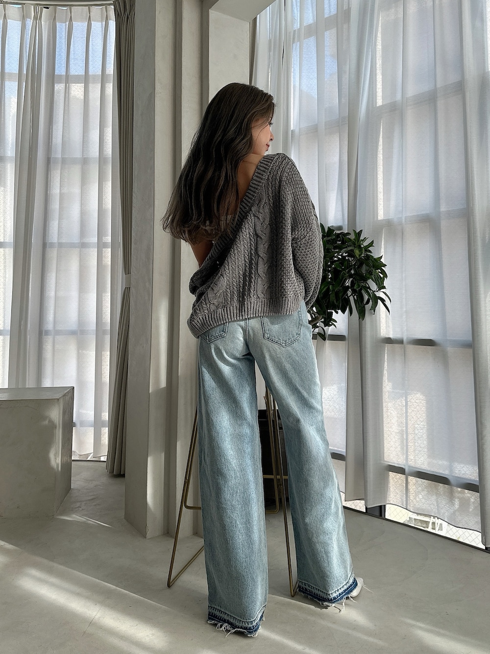 ブルー系のニット/セーター、ブルー系のデニムパンツ、ホワイト系のパンプスを着用したレディースの夏コーディネートの3枚目の写真