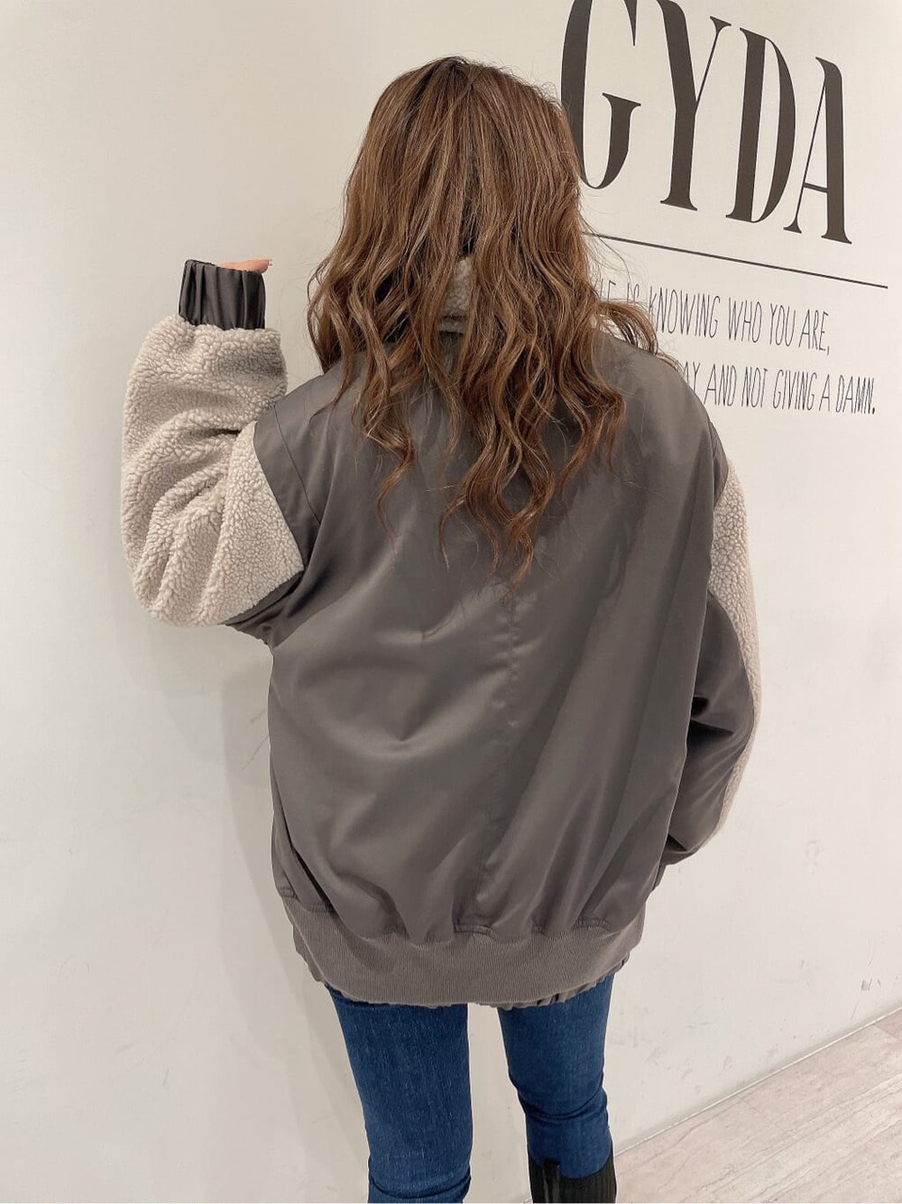 ブラック系のバックパック/リュック、ブラック系のブーツ、ブルー系のデニムパンツを着用したレディースの秋コーディネートの7枚目の写真