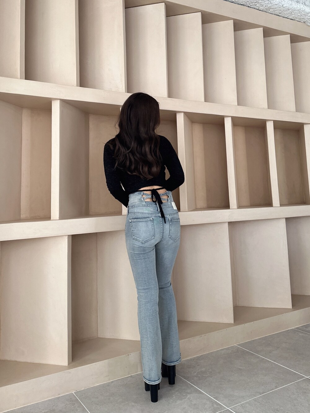 ブラック系のブーツ、ブルー系のデニムパンツ、ブラック系のニット/セーターを着用したレディースの秋コーディネートの7枚目の写真