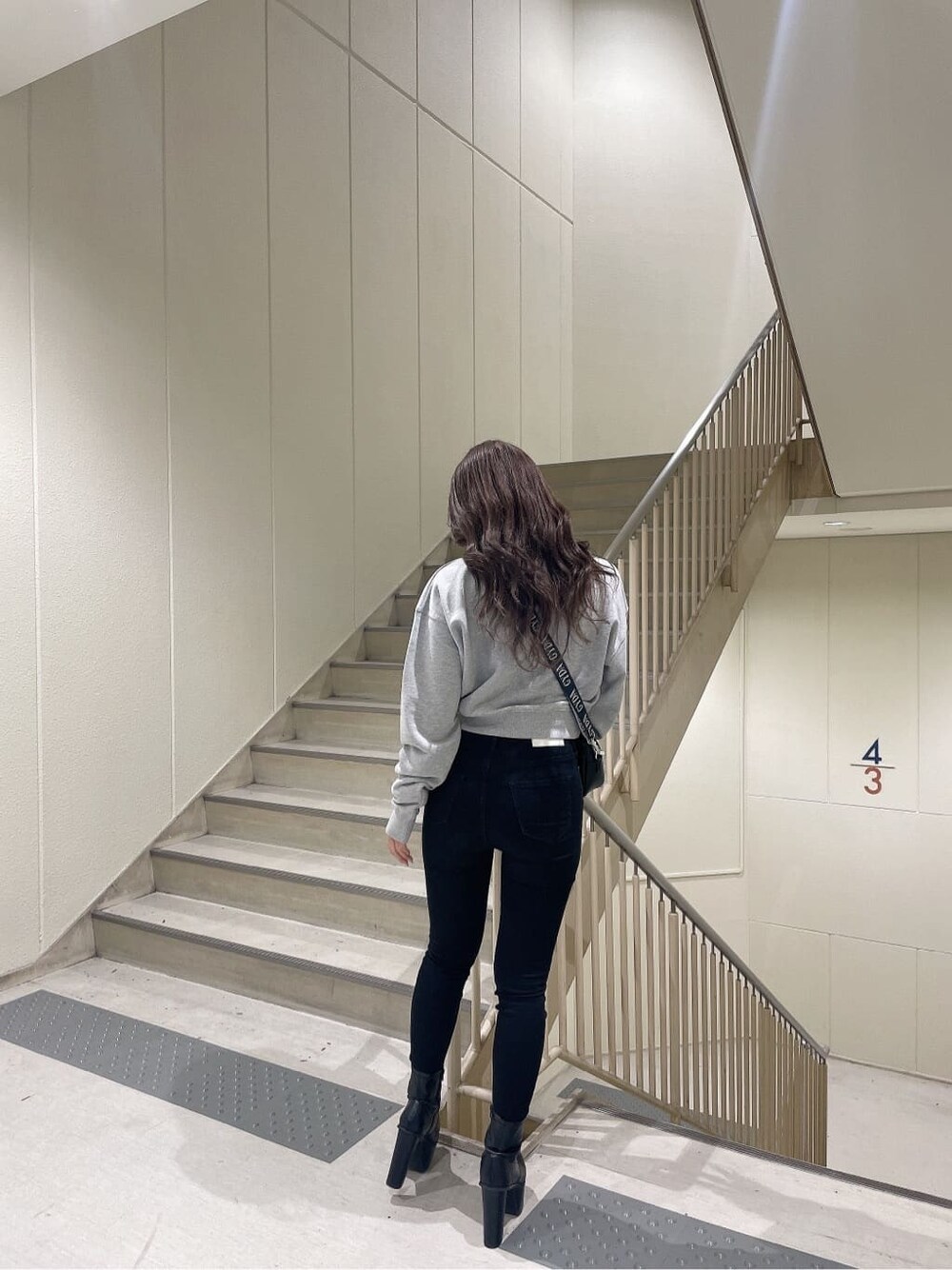 その他のデニムパンツ、ブラック系のブーツ、グレー系のスウェットを着用したレディースの秋コーディネートの4枚目の写真