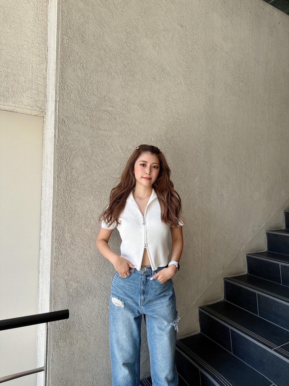 ホワイト系のニット/セーター、ブルー系のデニムパンツ、ブラック系のパンプスを着用したレディースの夏コーディネートの4枚目の写真