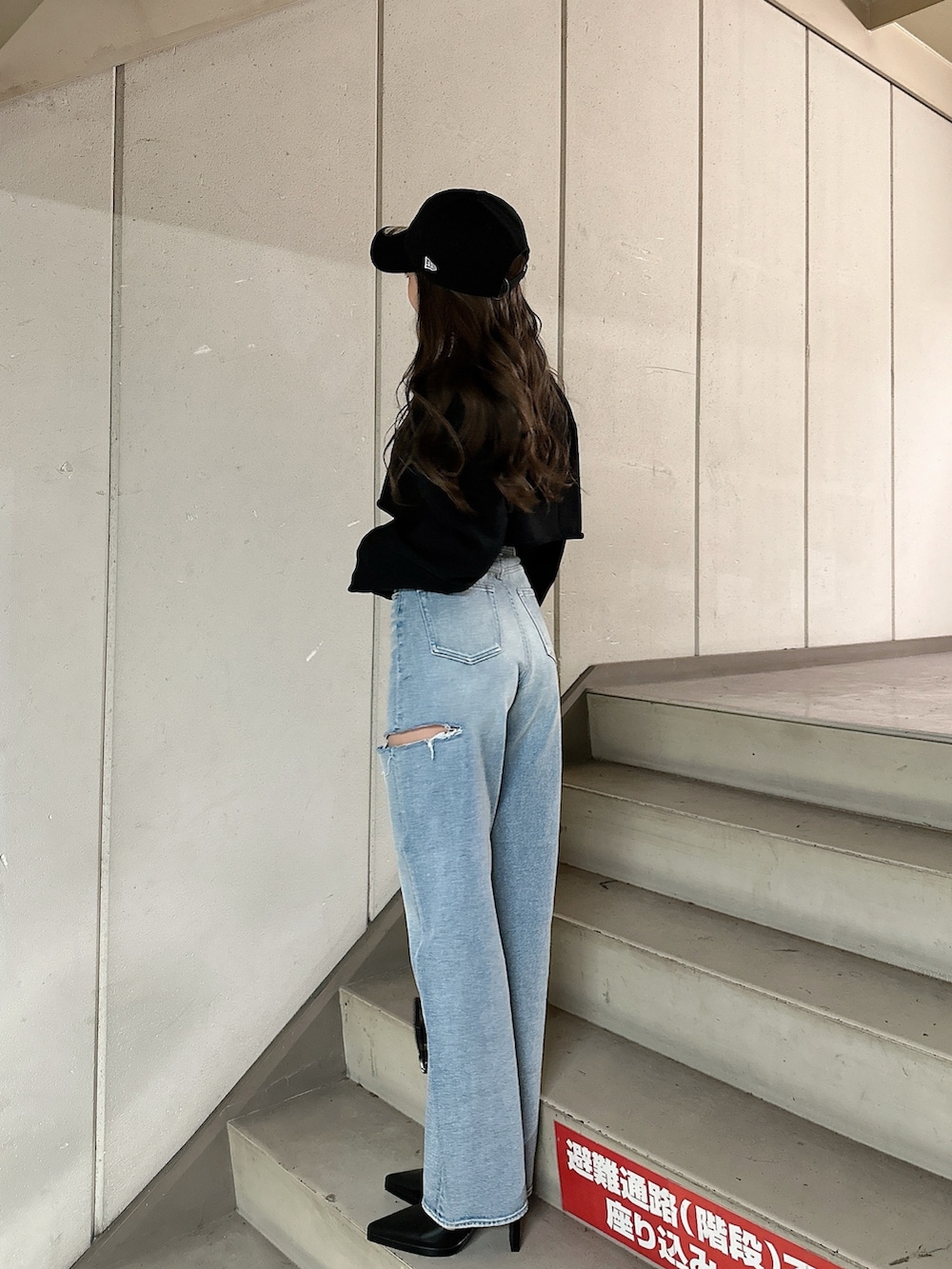 ブラック系のスウェット、ブルー系のデニムパンツ、ブラック系のバックパック/リュックを着用したレディースの冬コーディネートの3枚目の写真