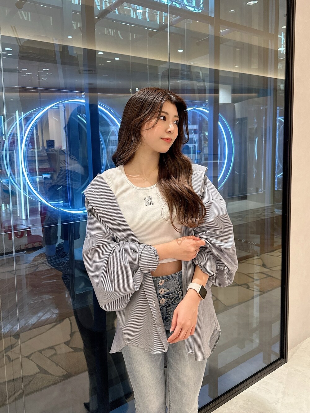 ブルー系のシャツ/ブラウス、ホワイト系のTシャツ/カットソー、ブルー系のデニムパンツを着用したレディースの春コーディネートの5枚目の写真