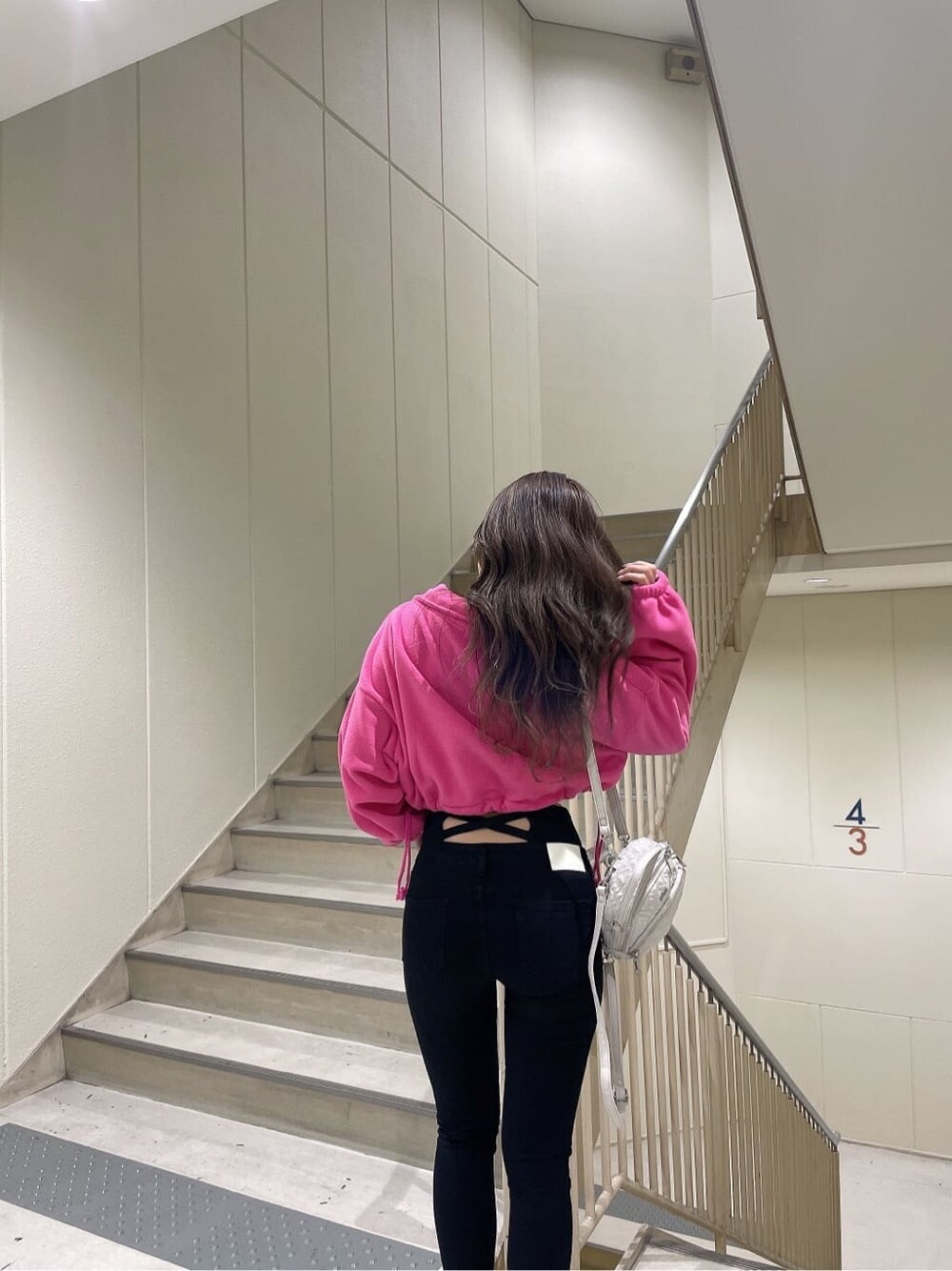 ブラック系のブーツ、ピンク系のTシャツ/カットソー、ブラック系のデニムパンツを着用したレディースの秋コーディネートの6枚目の写真