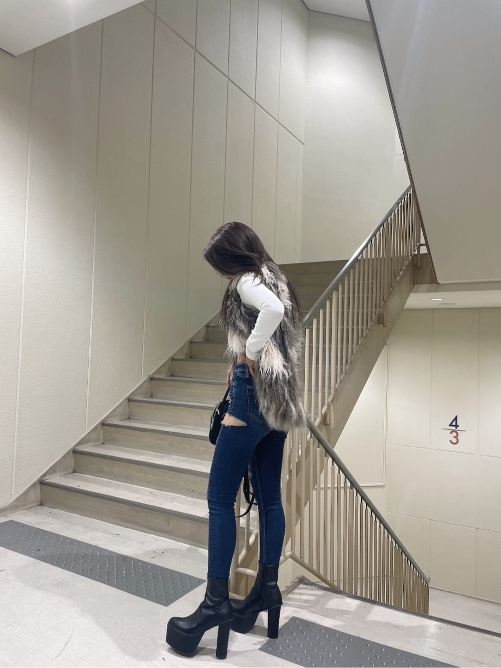 ブラック系のブーツ、ブルー系のデニムパンツ、ブラック系のバックパック/リュックを着用したレディースの秋コーディネートの5枚目の写真