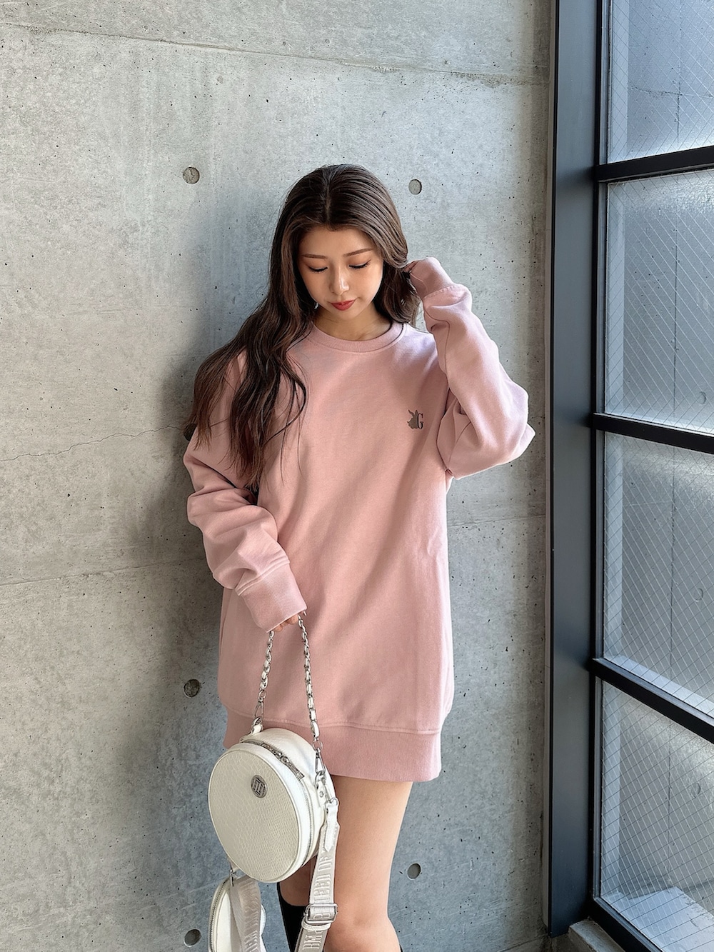 ホワイト系のハンドバッグ、ブラック系のブーツを着用したレディースの秋コーディネートの2枚目の写真