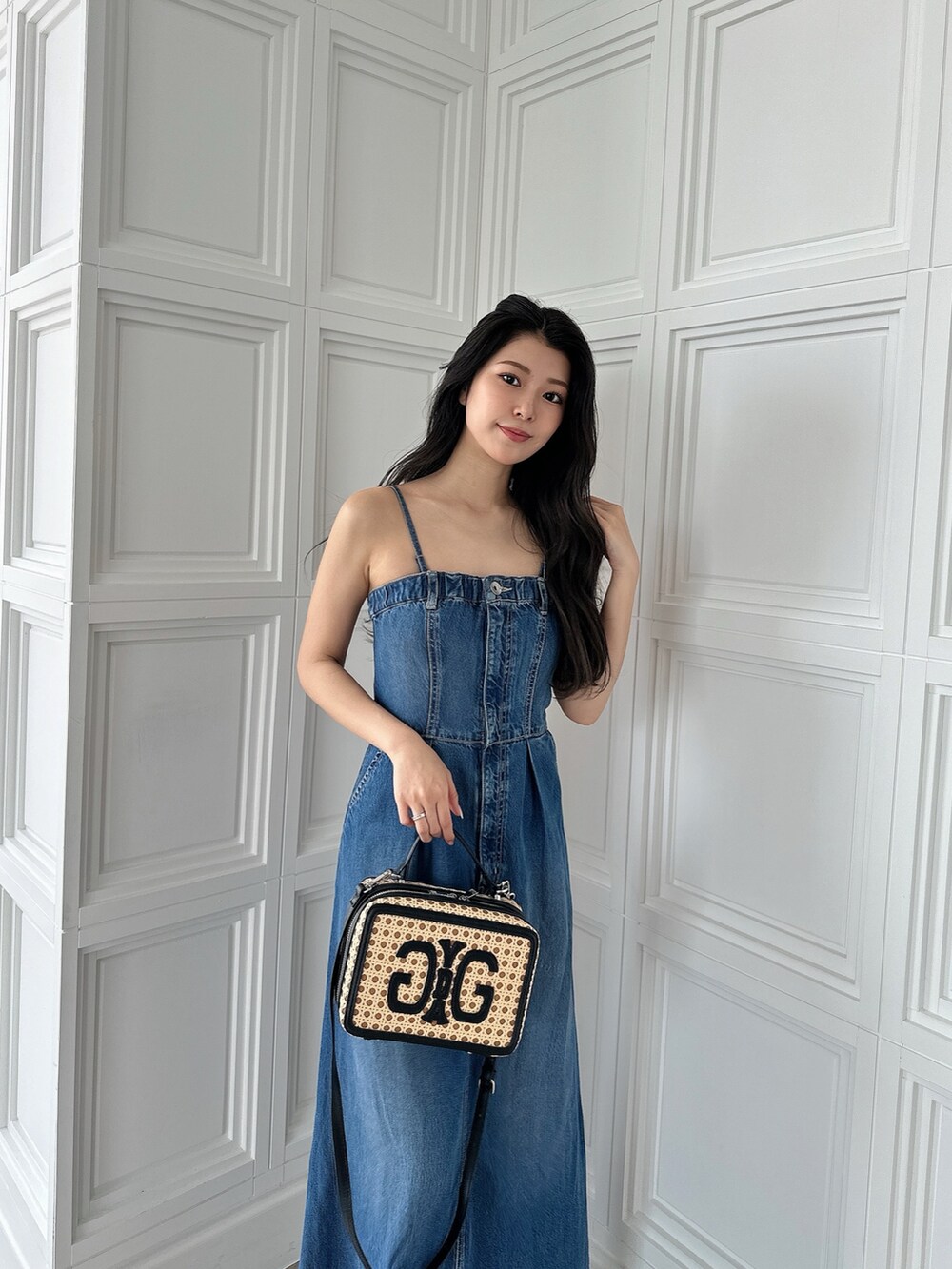 ベージュ系のショルダーバッグ、ホワイト系のパンプス、ブルー系のワンピースを着用したレディースの夏コーディネートの4枚目の写真