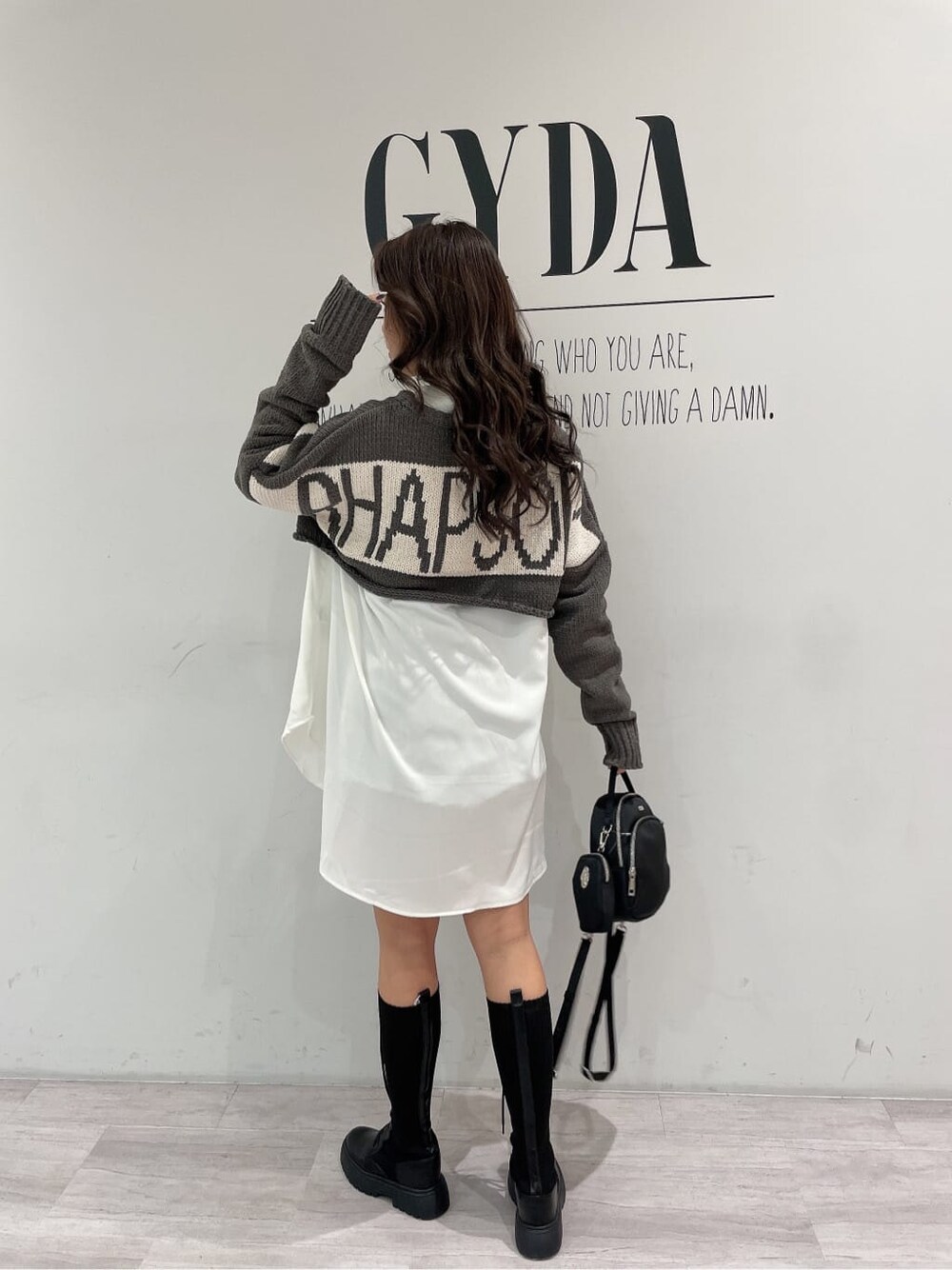 ブラック系のその他シューズ、ブラック系のバックパック/リュック、ホワイト系のシャツ/ブラウスを着用したレディースの冬コーディネートの5枚目の写真