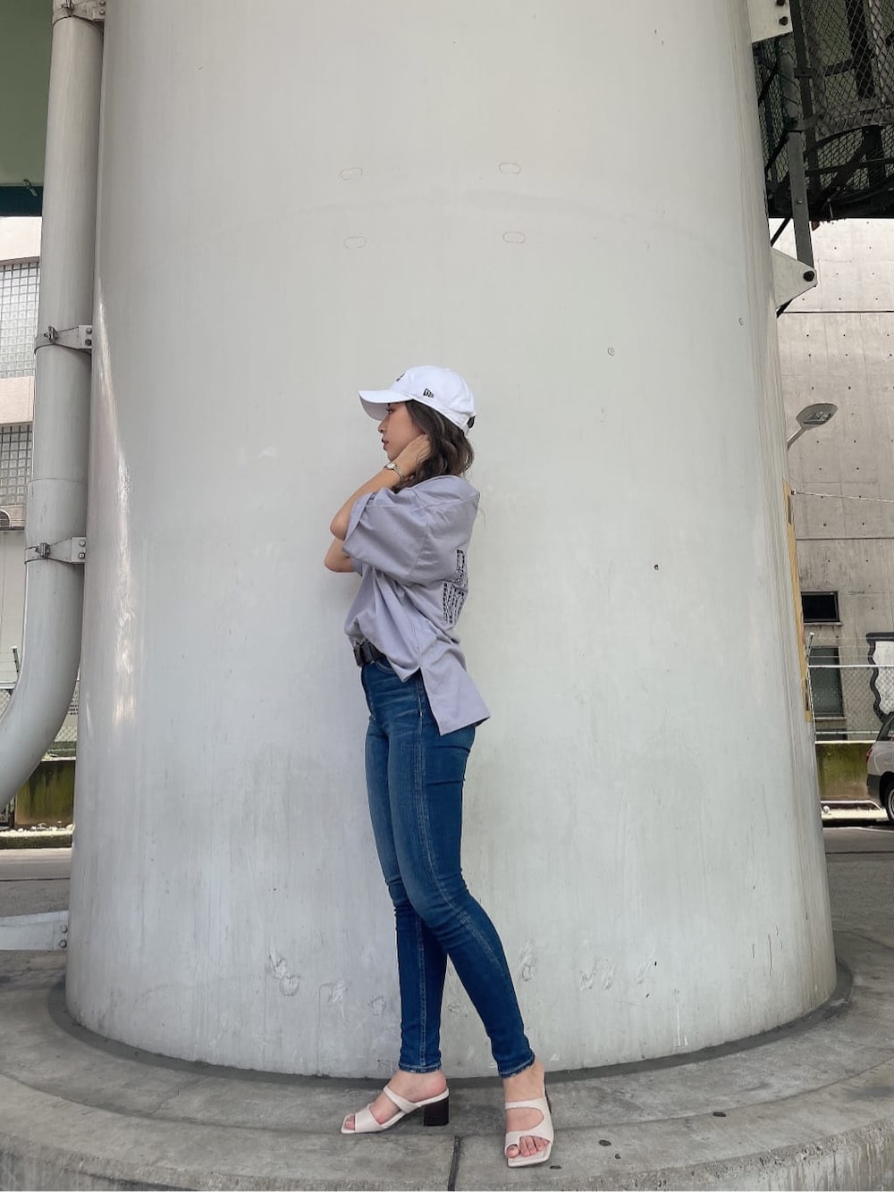 ブルー系のデニムパンツ、ホワイト系のサンダル、パープル系のTシャツ/カットソーを着用したレディースの夏コーディネートの3枚目の写真
