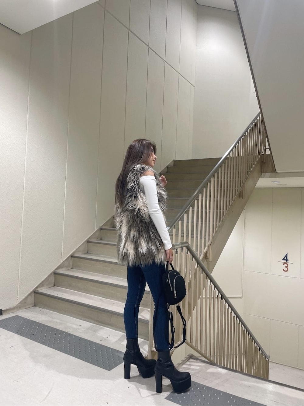 ブラック系のブーツ、ブルー系のデニムパンツ、ブラック系のバックパック/リュックを着用したレディースの秋コーディネートの3枚目の写真