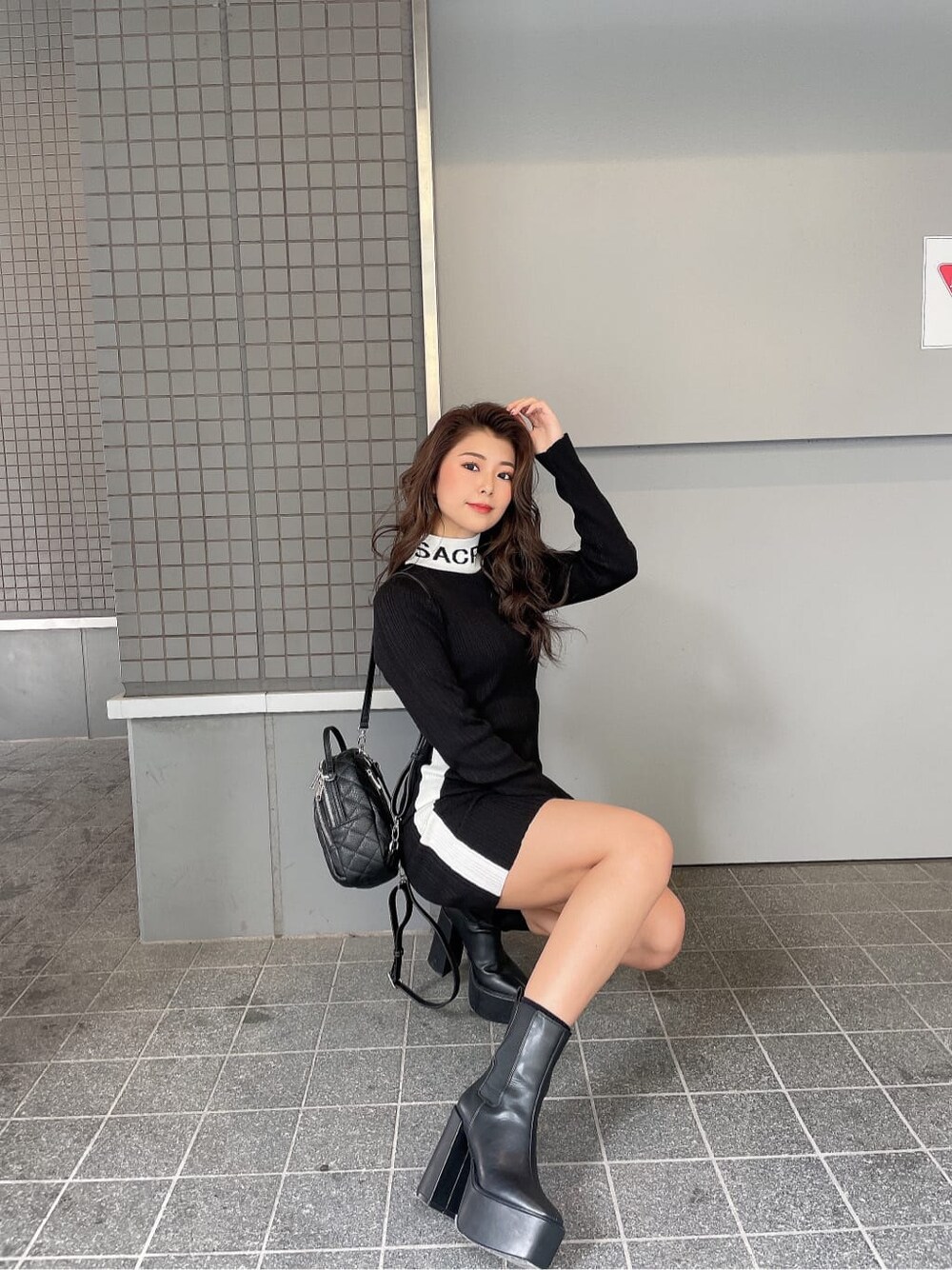 ブラック系のブーツ、ブラック系のバックパック/リュック、ブラック系のワンピースを着用したレディースの秋コーディネートの2枚目の写真