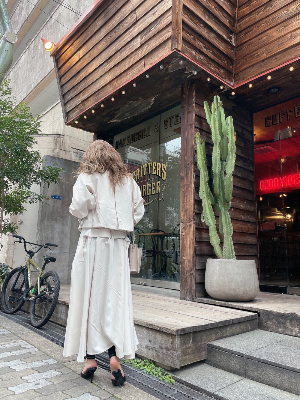 ブラック系のパンプス、ブラック系のデニムパンツ、ブラック系のキャミソールを着用したレディースの冬コーディネートの2枚目の写真