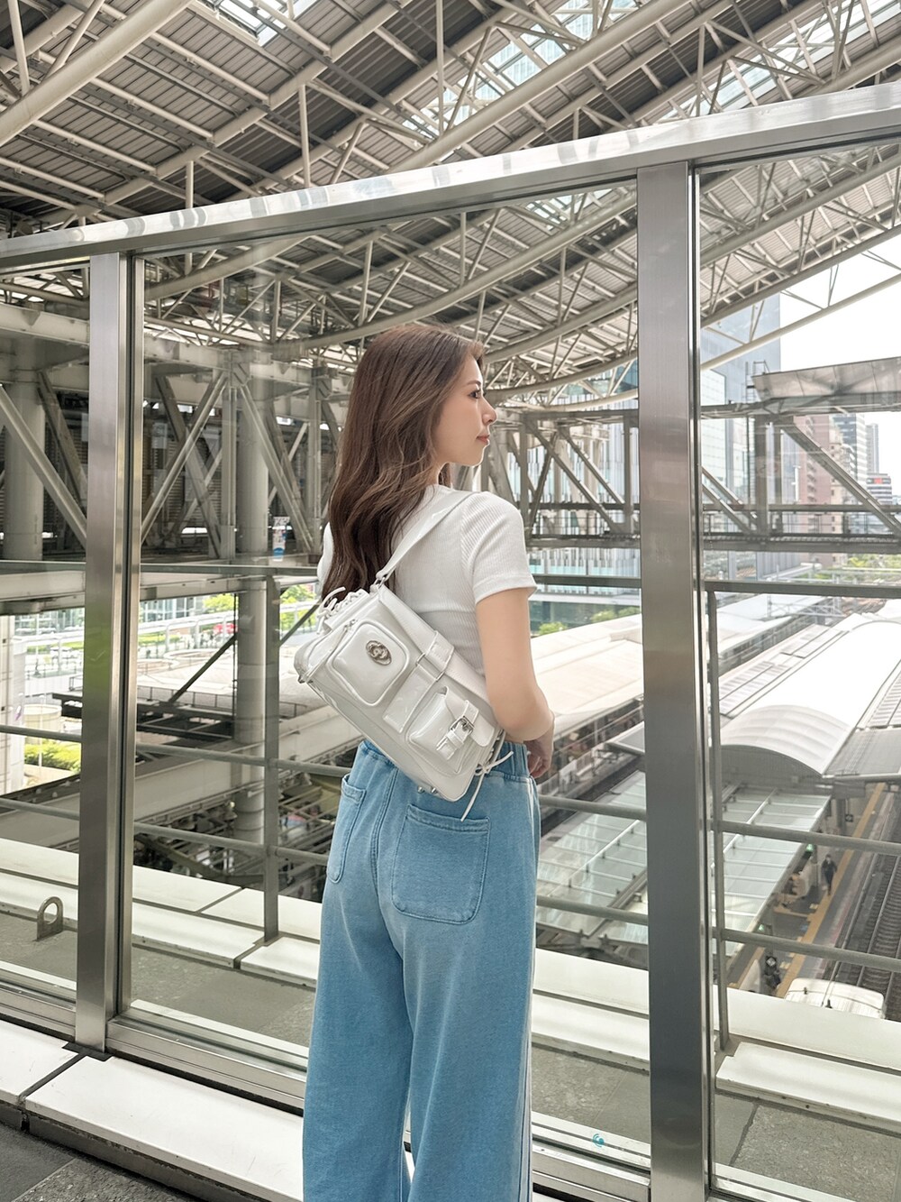 ホワイト系のハンドバッグ、ホワイト系のTシャツ/カットソー、ブルー系のその他パンツを着用したレディースの春コーディネートの3枚目の写真