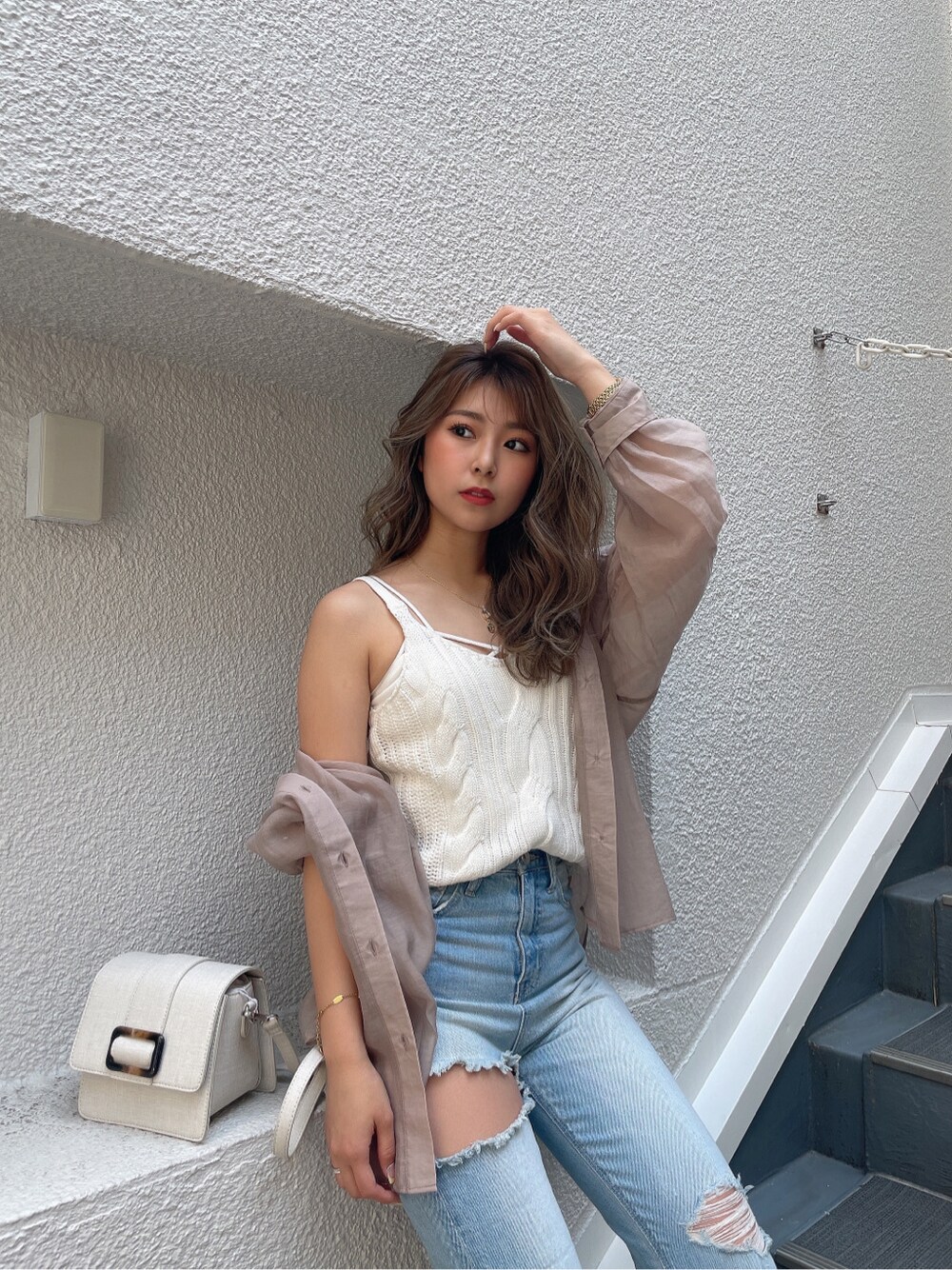 ホワイト系のキャミソール、ホワイト系のキャミソール、ブルー系のデニムパンツを着用したレディースの春コーディネートの2枚目の写真