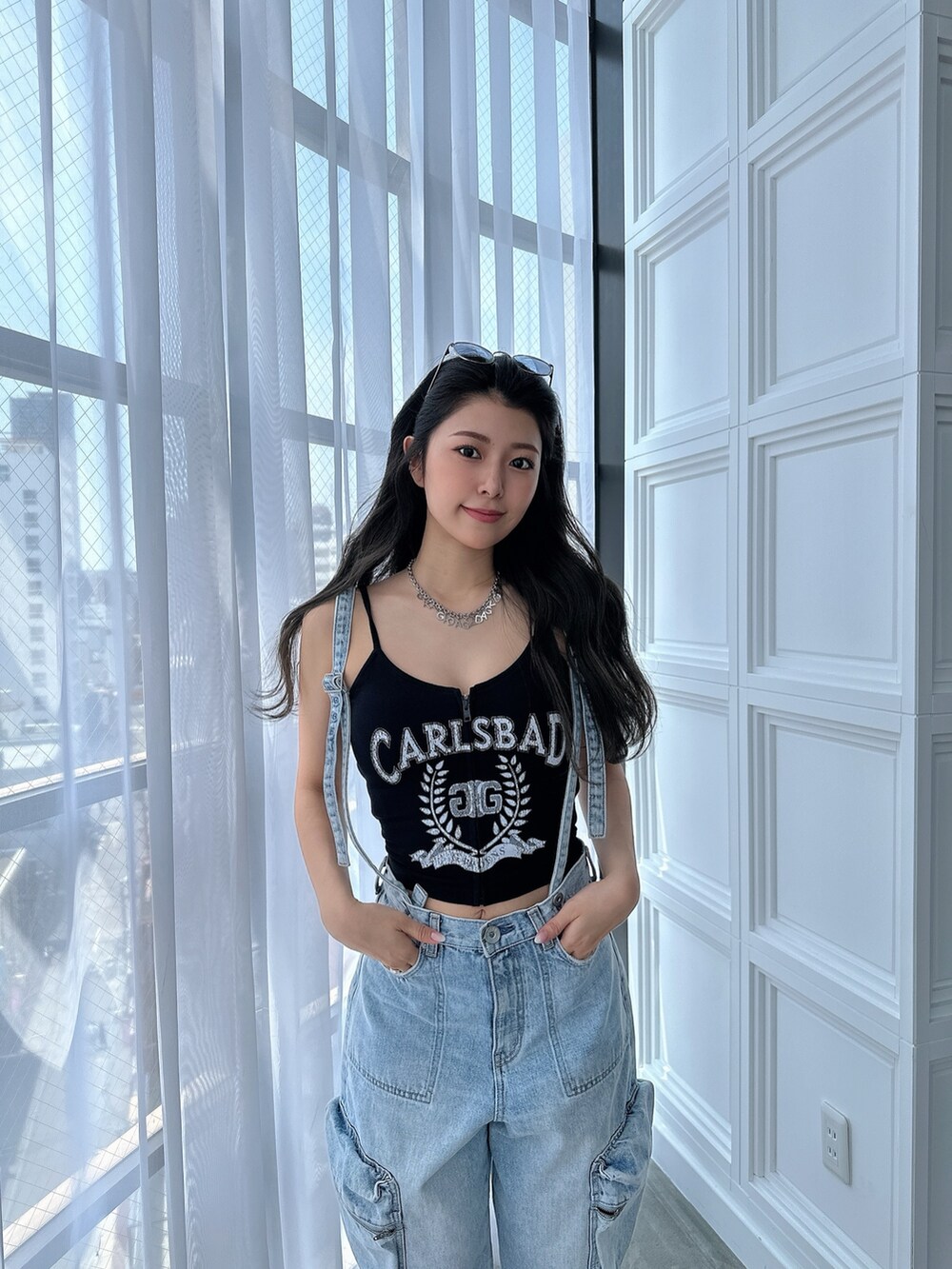 ブラック系のキャミソール、ブルー系のデニムパンツ、ブラック系のサンダルを着用したレディースの夏コーディネートの5枚目の写真