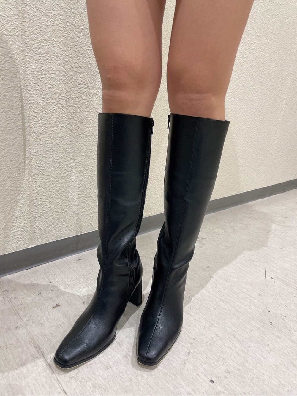 ベージュ系のスタジャン、ブラック系のブーツ、ホワイト系のワンピースを着用したレディースの秋コーディネートの9枚目の写真