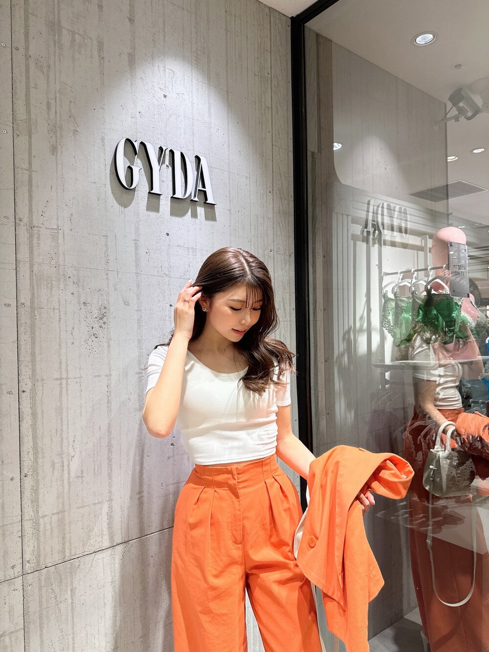 ホワイト系のTシャツ/カットソー、オレンジ系のテーラードジャケット、オレンジ系のスラックスを着用したレディースの春コーディネートの7枚目の写真