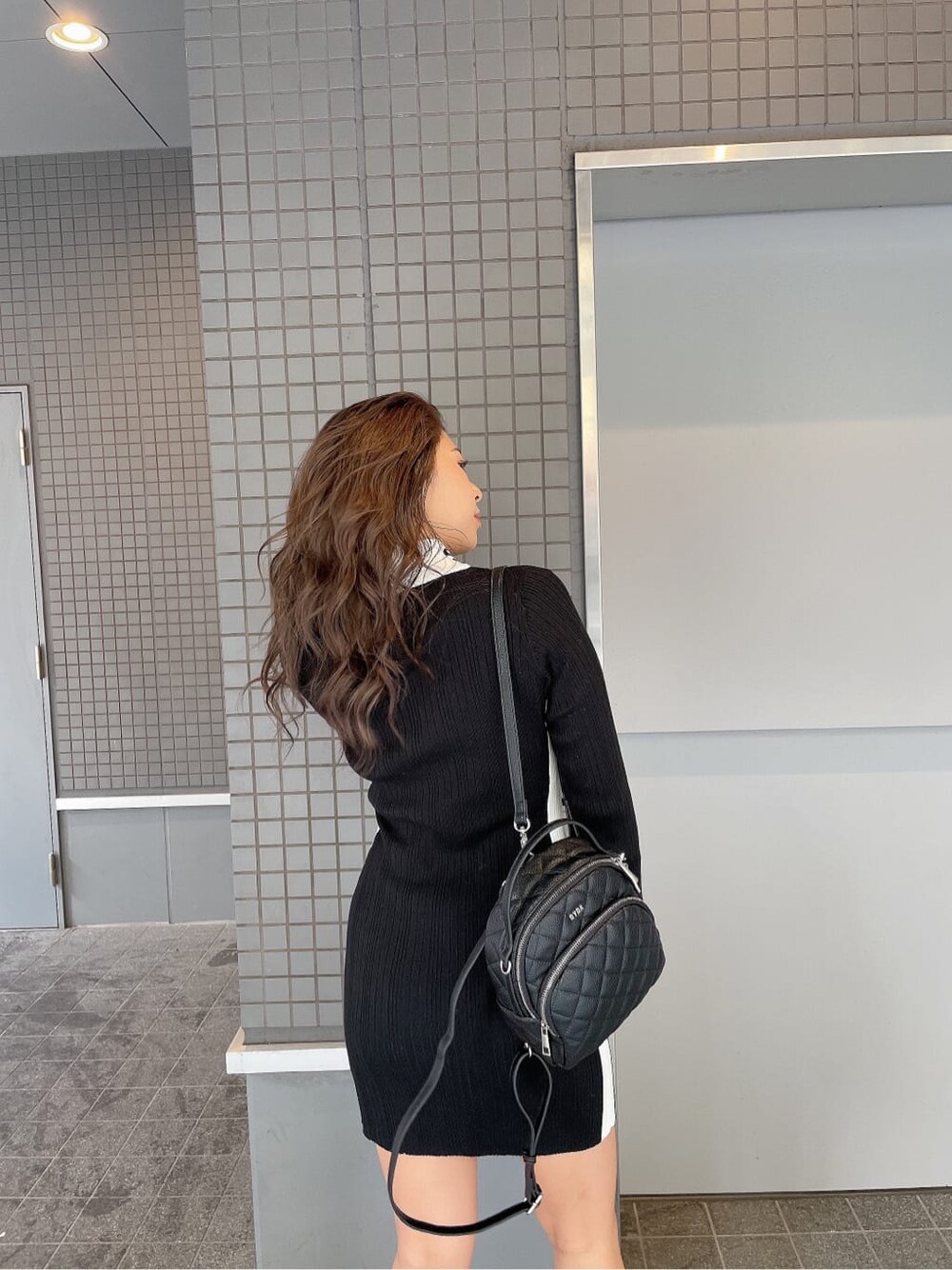 ブラック系のブーツ、ブラック系のバックパック/リュック、ブラック系のワンピースを着用したレディースの秋コーディネートの7枚目の写真