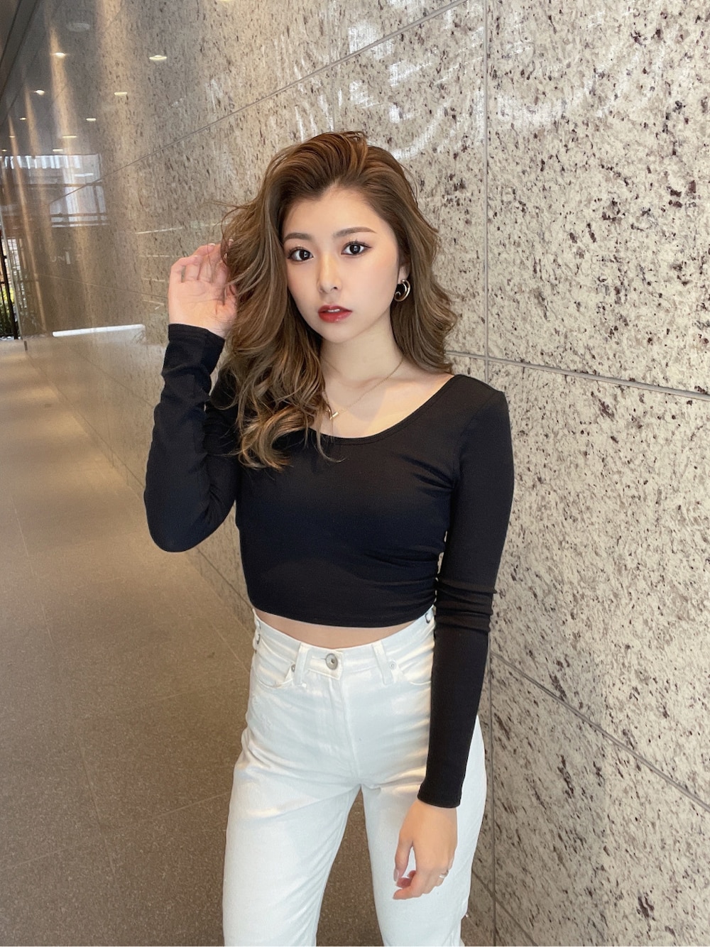 ホワイト系のパンプス、ホワイト系のデニムパンツ、ゴールド系のピアス(両耳用)を着用したレディースの冬コーディネートの5枚目の写真