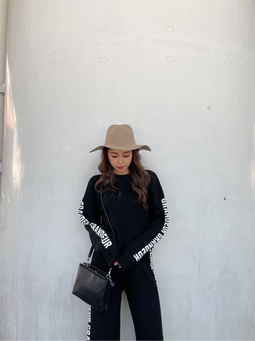 ブラック系のパンプス、ブラック系のニット/セーター、ブラック系のショルダーバッグを着用したレディースの冬コーディネートの6枚目の写真