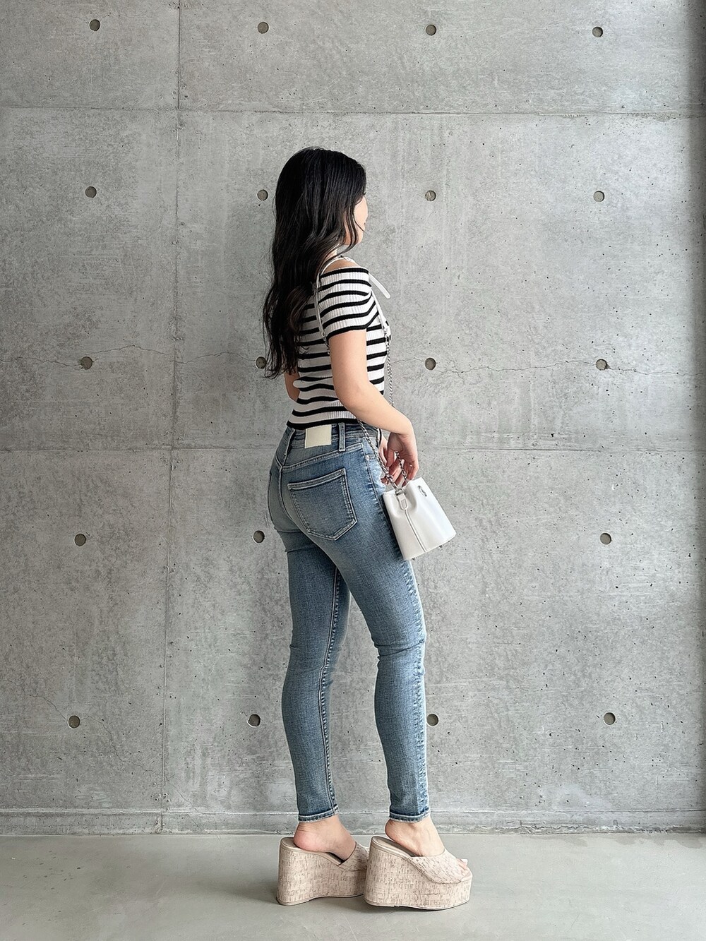 ホワイト系のサンダル、その他のニット/セーター、ブルー系のデニムパンツを着用したレディースの夏コーディネートの2枚目の写真