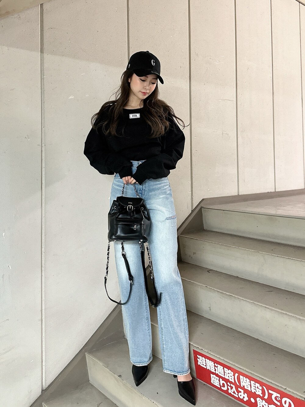 ブラック系のスウェット、ブルー系のデニムパンツ、ブラック系のバックパック/リュックを着用したレディースの冬コーディネートの2枚目の写真