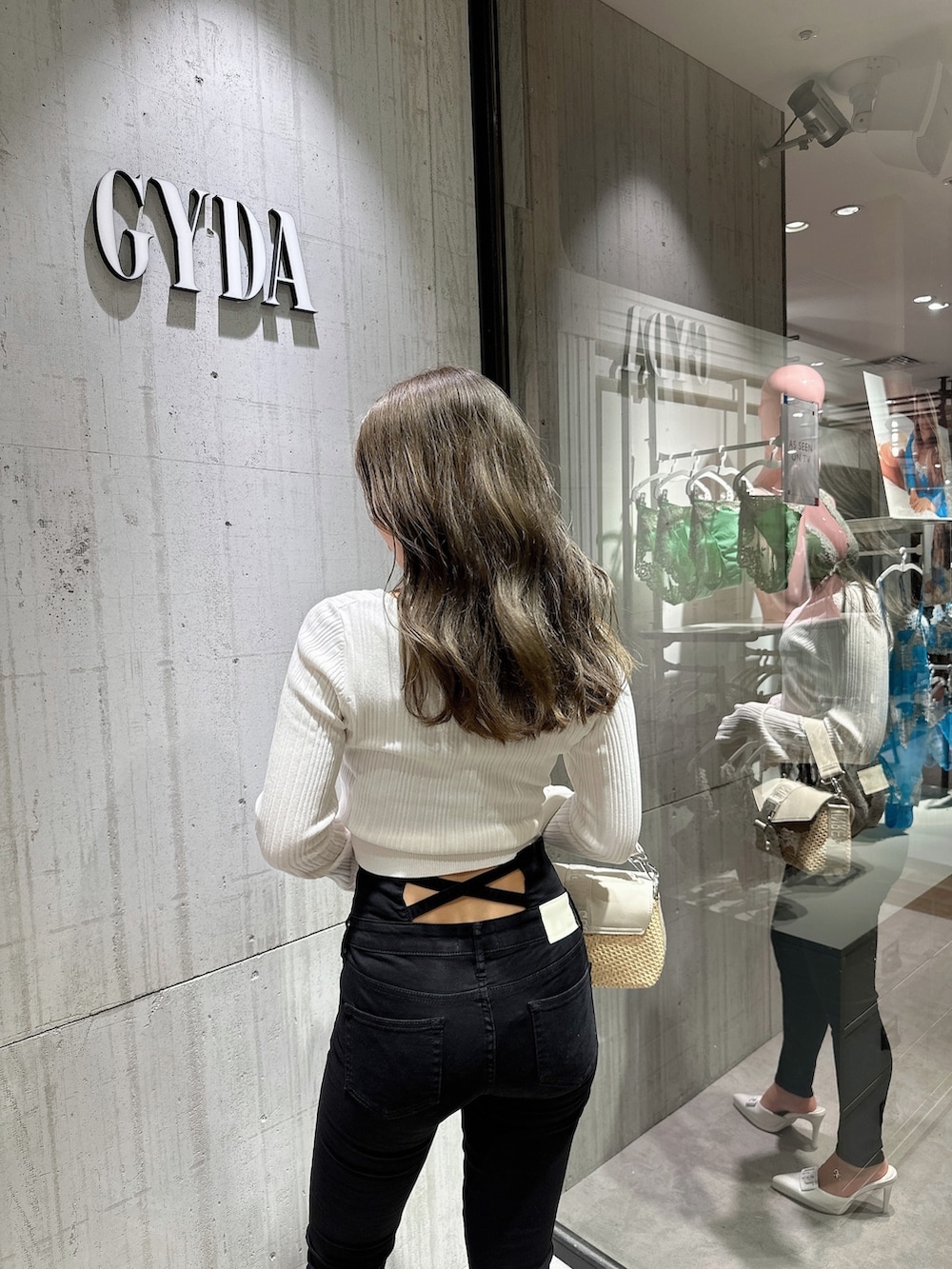 ホワイト系のカーディガン/ボレロ、ブラック系のデニムパンツ、ホワイト系のパンプスを着用したレディースの夏コーディネートの6枚目の写真