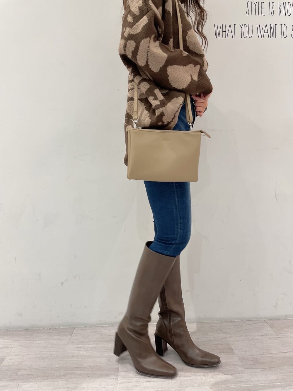 ブラウン系のブーツ、ブルー系のデニムパンツ、ベージュ系のショルダーバッグを着用したレディースの秋コーディネートの8枚目の写真