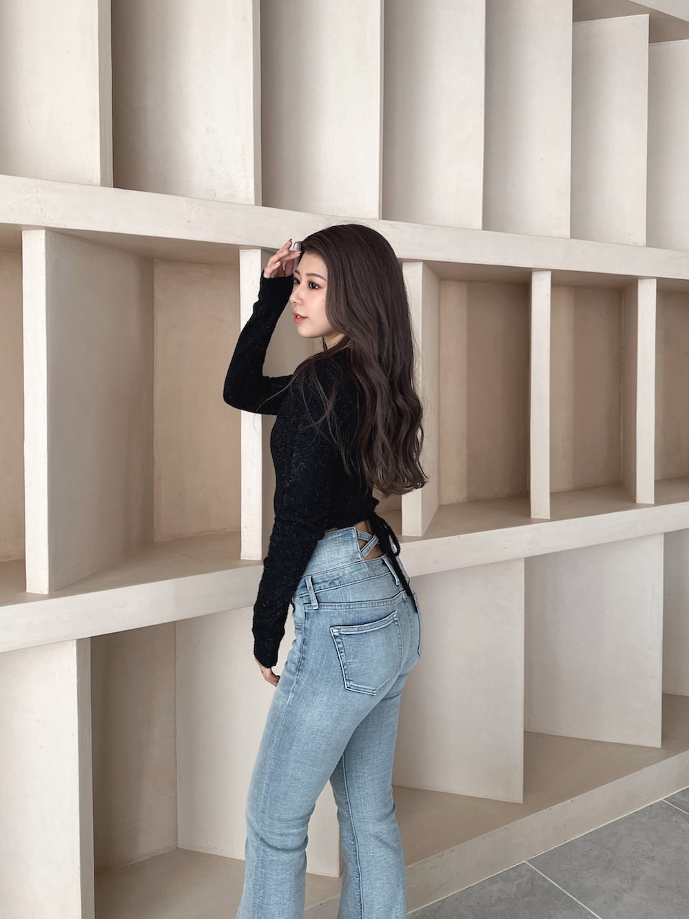 ブラック系のブーツ、ブルー系のデニムパンツ、ブラック系のニット/セーターを着用したレディースの秋コーディネートの3枚目の写真