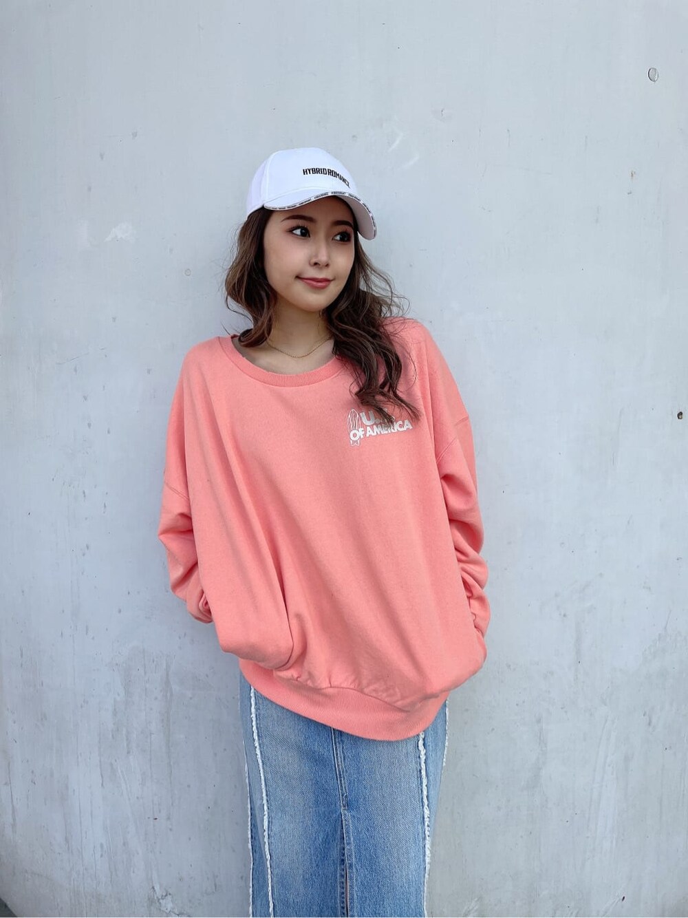 ホワイト系のブーツ、オレンジ系のスウェット、ブルー系のデニムスカートを着用したレディースの冬コーディネートの7枚目の写真