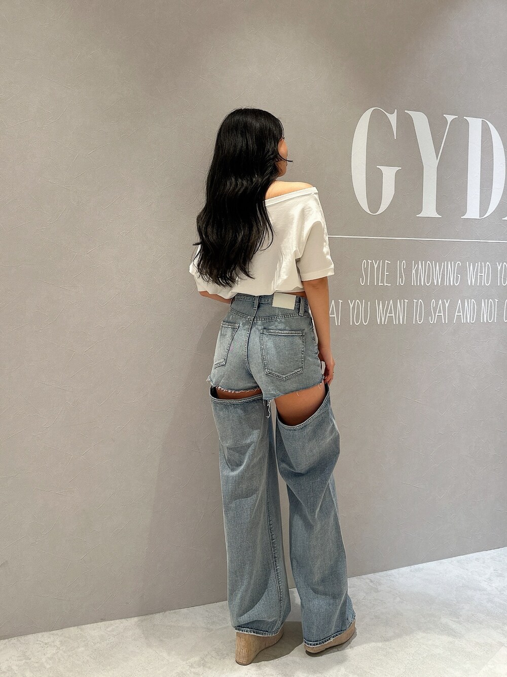 ホワイト系のサンダル、ホワイト系のTシャツ/カットソー、ブルー系のデニムパンツを着用したレディースの夏コーディネートの7枚目の写真