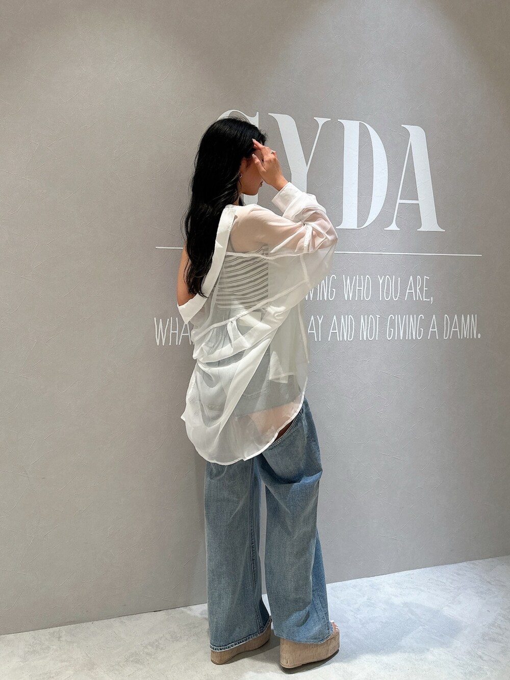 ホワイト系のキャミソール、ブルー系のデニムパンツ、ホワイト系のサンダルを着用したレディースの夏コーディネートの6枚目の写真