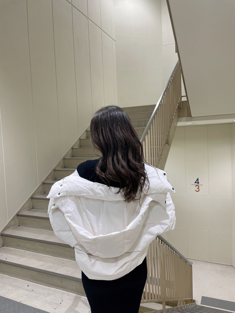 ブラック系のワンピース、ブラック系のダウンジャケット/コート、ブラック系のブーツを着用したレディースの冬コーディネートの5枚目の写真